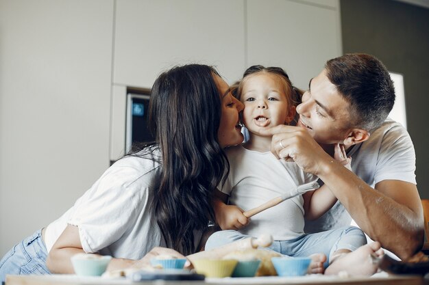 Familia cocina la masa para galletas en la cocina