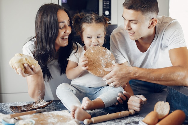 Familia cocina la masa para galletas en la cocina