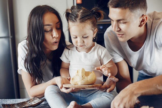 Familia cocina la masa para galletas en la cocina