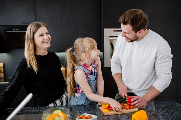 Familia cocinando cena y charlando