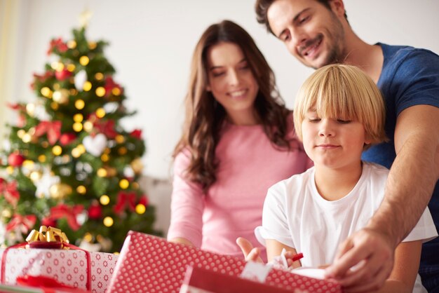 Familia comenzando la Navidad abriendo regalos
