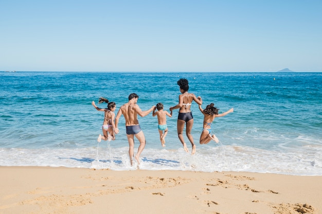 Familia corriendo al agua en la playa