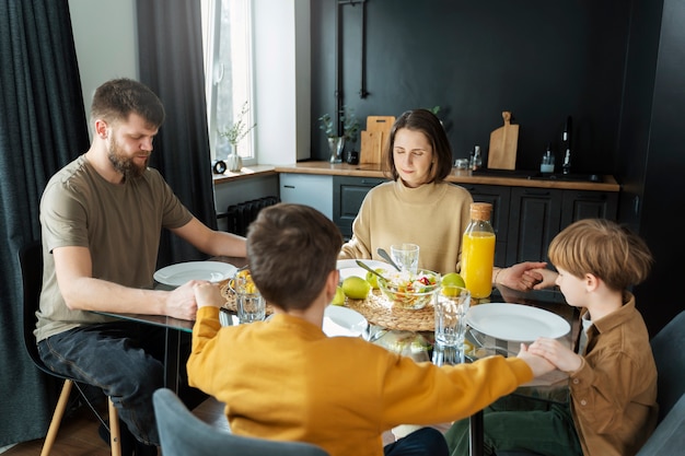 Foto gratuita familia cristiana comiendo juntos plano medio