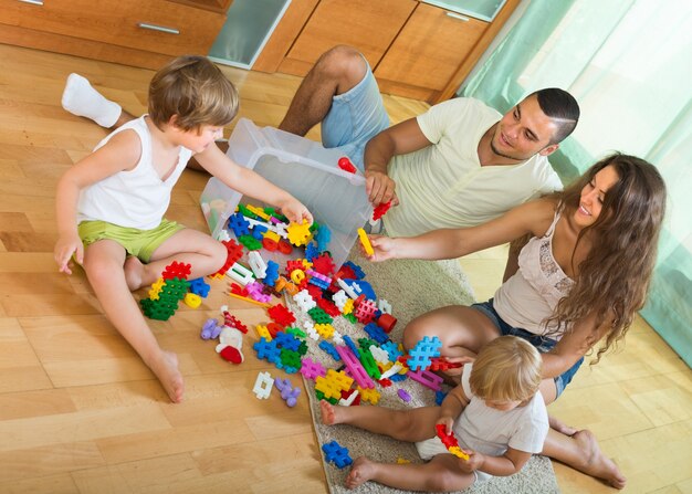 Familia de cuatro en casa con juguetes