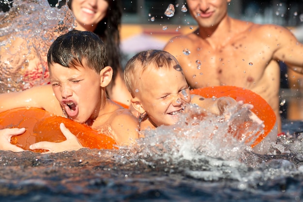 Familia de cuatro disfrutando de un día en la piscina juntos