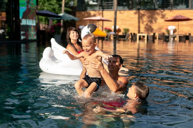 Familia de cuatro disfrutando de un día en la piscina juntos