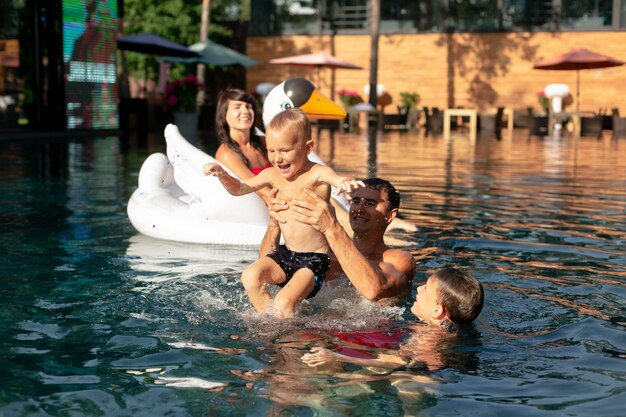 Familia de cuatro disfrutando de un día en la piscina juntos