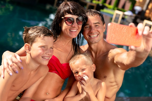 Familia de cuatro disfrutando de un día en la piscina juntos