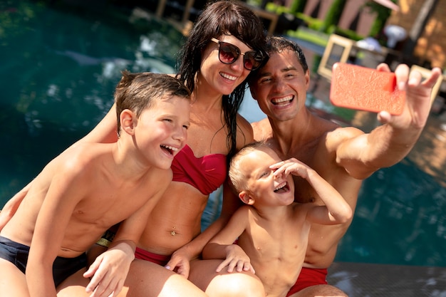 Familia de cuatro disfrutando de un día en la piscina juntos