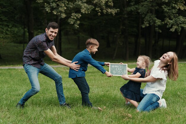 Familia de cuatro miembros que se divierten jugando en el parque