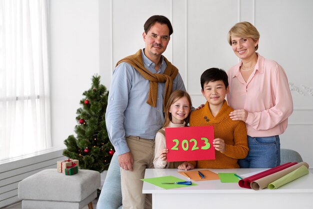 Familia de cuatro personas celebrando la víspera de año nuevo en casa juntos