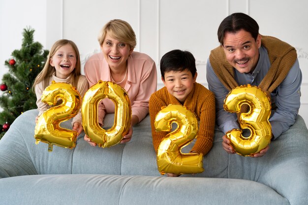 Familia de cuatro personas celebrando la víspera de año nuevo en casa juntos