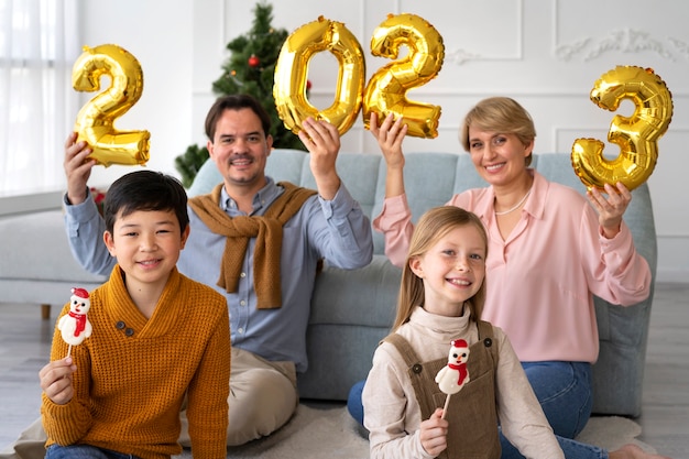 Familia de cuatro personas celebrando la víspera de año nuevo en casa juntos