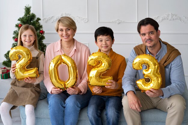 Familia de cuatro personas celebrando la víspera de año nuevo en casa juntos