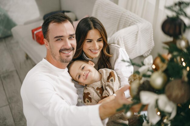 Familia de decorar un árbol de navidad en casa