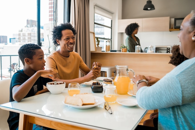 Familia desayunando juntos en casa.