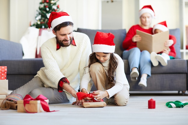 Familia desenvolver regalos de Navidad