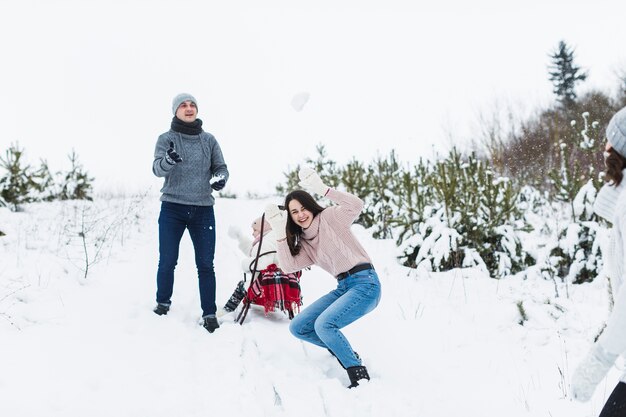 Familia divirtiéndose cerca de trineo