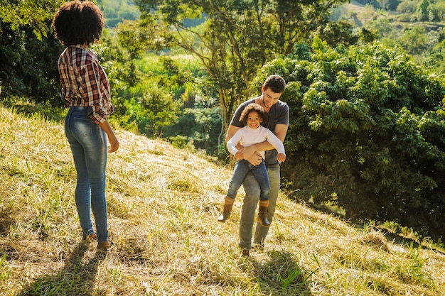 Familia divirtiéndose en colina soleada