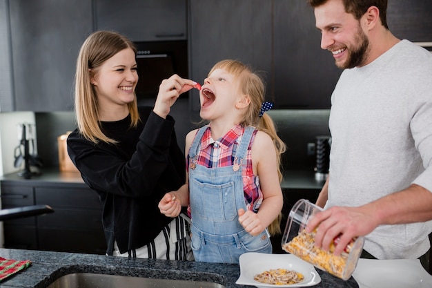 Familia divirtiéndose mientras cocina el desayuno