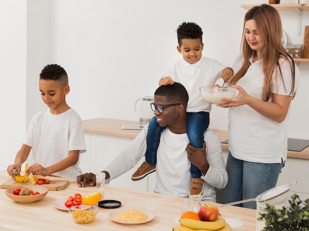 Familia divirtiéndose mientras hace algo de comida