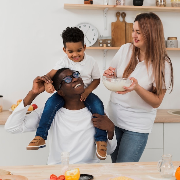 Familia divirtiéndose mientras prepara algo de comida en la cocina