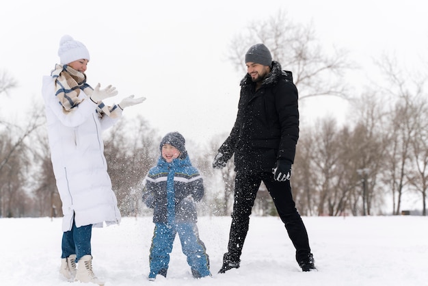 Familia divirtiéndose en la nieve.