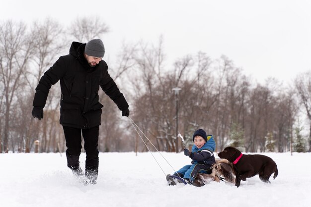 Familia divirtiéndose en la nieve.