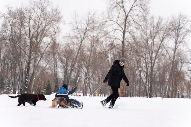 Familia divirtiéndose en la nieve.