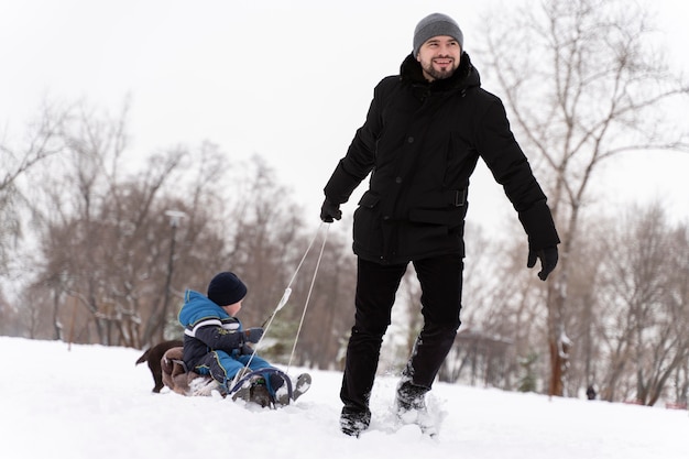 Familia divirtiéndose en la nieve.