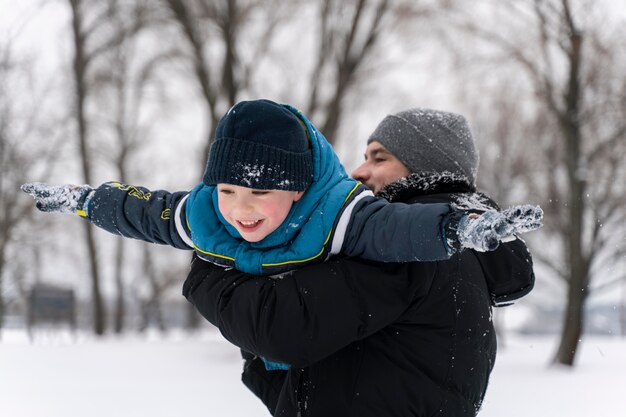 Familia divirtiéndose en la nieve.