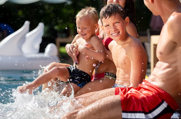 Familia con dos niños disfrutando de su día en la piscina.