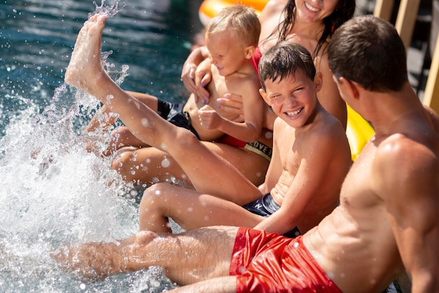 Familia con dos niños disfrutando de su día en la piscina.