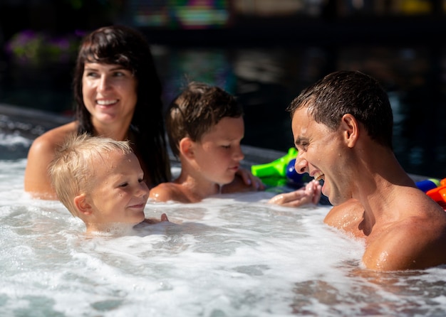 Familia con dos niños disfrutando de su día en la piscina.