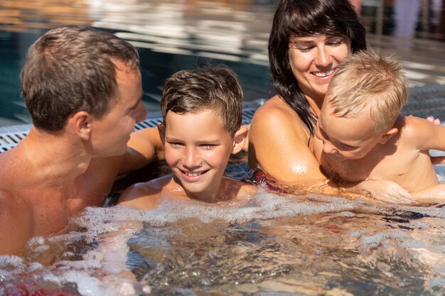 Familia con dos niños disfrutando de su día en la piscina.