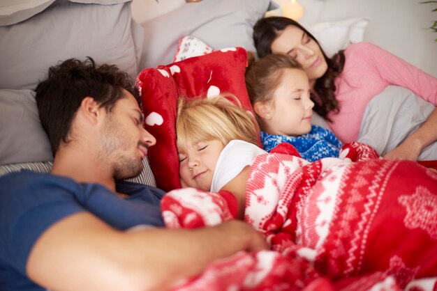 Familia durmiendo juntos en la cama