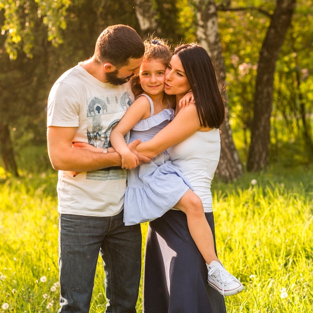 Familia feliz abrazando en el parque