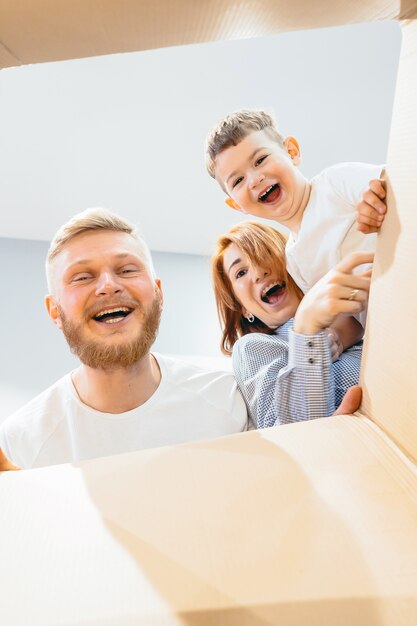 Familia feliz acaba de mudarse a una casa nueva y mirar la caja