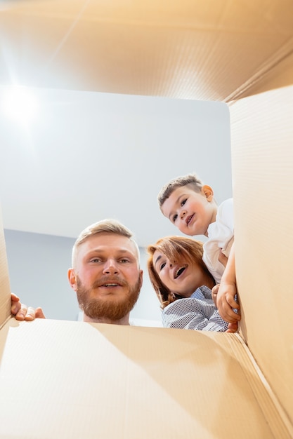 Familia feliz acaba de mudarse a una casa nueva y mirar la caja