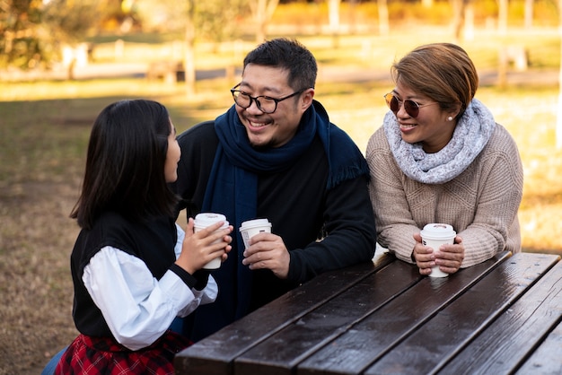 Foto gratuita familia feliz al aire libre plano medio