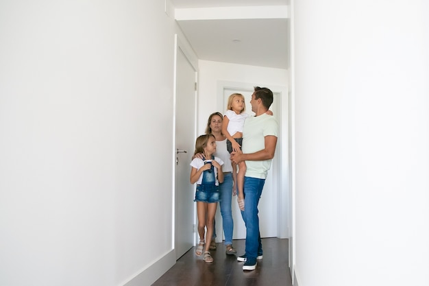 Familia feliz atravesando el pasillo de su nueva casa