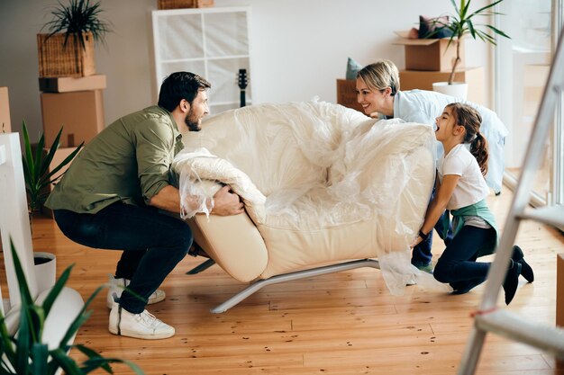 Familia feliz cargando muebles en su nuevo hogar