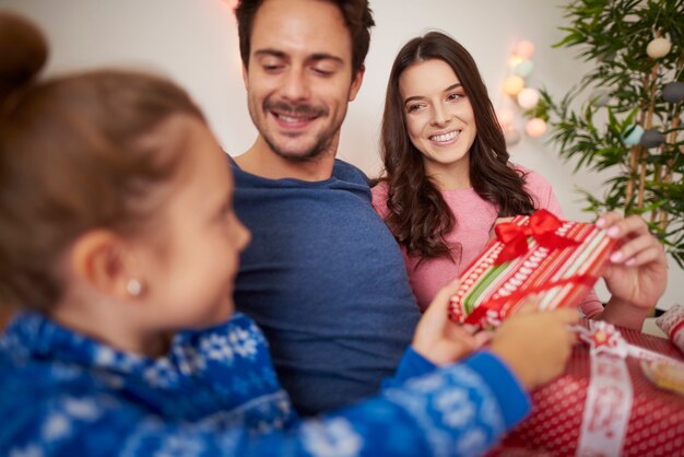 Familia feliz celebrando la Navidad en la cama