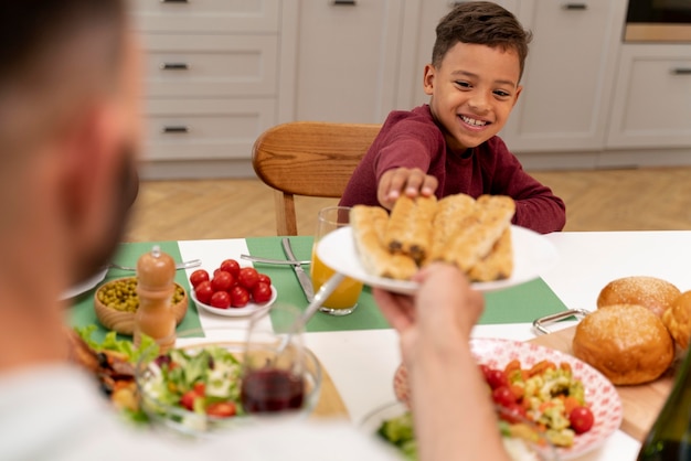 Foto gratuita familia feliz cenando juntos