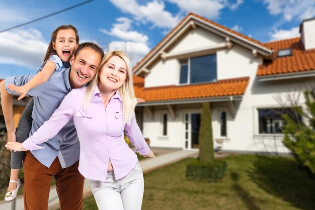 Familia feliz cerca de casa nueva. concepto de bienes raíces.