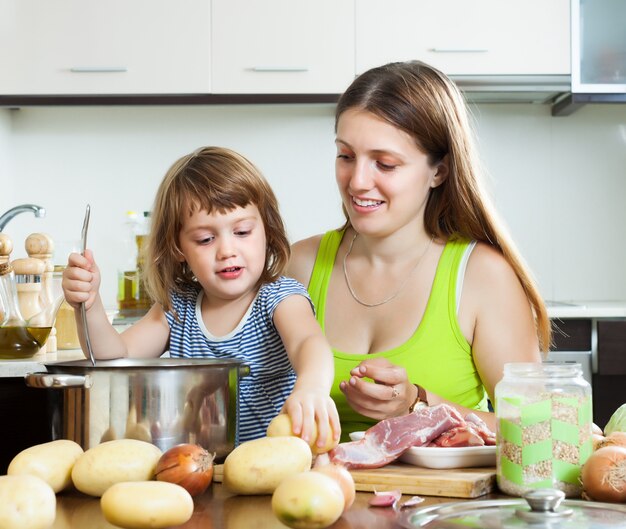 Familia feliz cocinando sopa