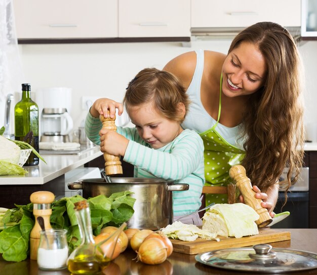 Familia feliz cocinando sopa