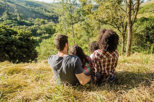 Foto gratuita familia feliz en colina vista de detrás