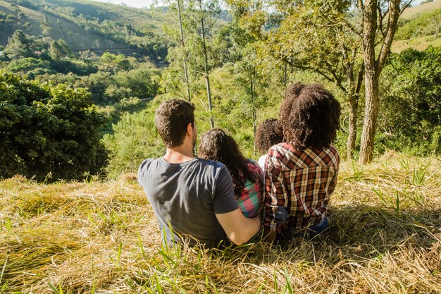 Familia feliz en colina vista de detrás