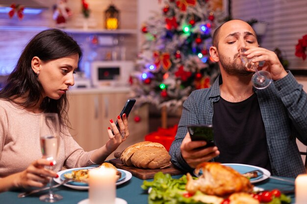 Familia feliz comiendo una deliciosa cena sentado en la mesa de comedor